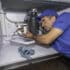 Plumbing tips plumber working under a kitchen sink.