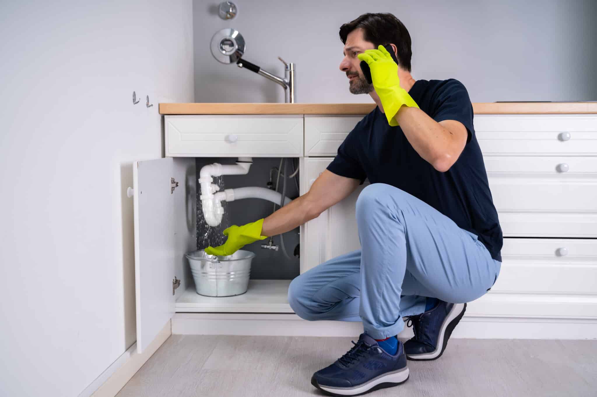 A man calls a plumber for a winter plumbing check-up after noticing a water leak.