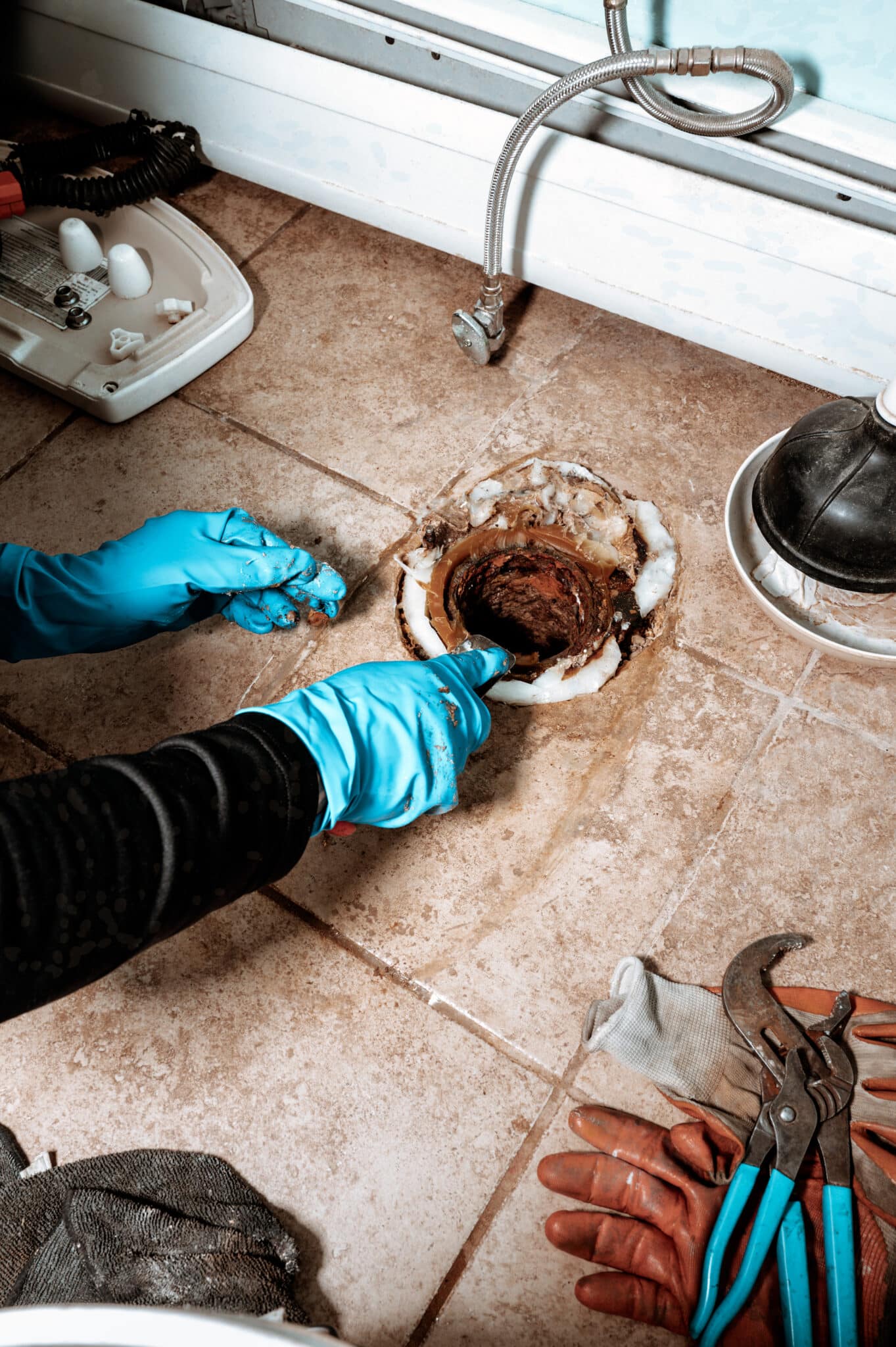 Close-up view of a Professional plumber replacing, Toilet Flange Repair.